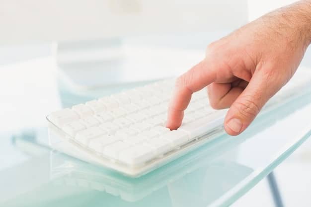 A close-up of an office worker's hands hovering over a keyboard, with a blurred image of a fraudulent email displayed on the screen. The email appears to be from a high-level executive requesting an urgent wire transfer.