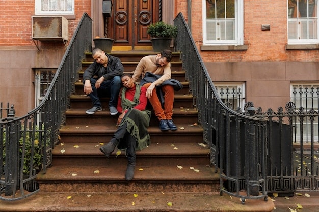 Three neighbors standing on a porch, observing and discussing something happening down the street. They appear concerned but are communicating calmly and thoughtfully. The setting is a residential neighborhood in the late afternoon.