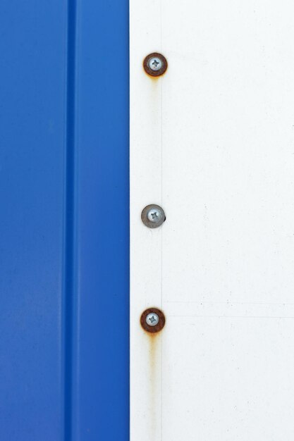 A close-up of a reinforced door frame with a long strike plate and heavy-duty screws, showcasing the enhanced security measures. The door is painted a neutral color, and the surrounding wall is clean and well-maintained.