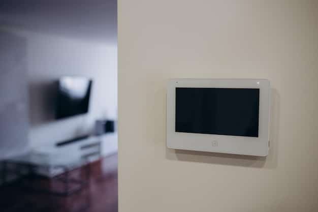 A smart home security control panel displaying a live feed from a security camera. The panel is mounted on a wall in a modern living room, and the camera shows a clear view of the front yard.